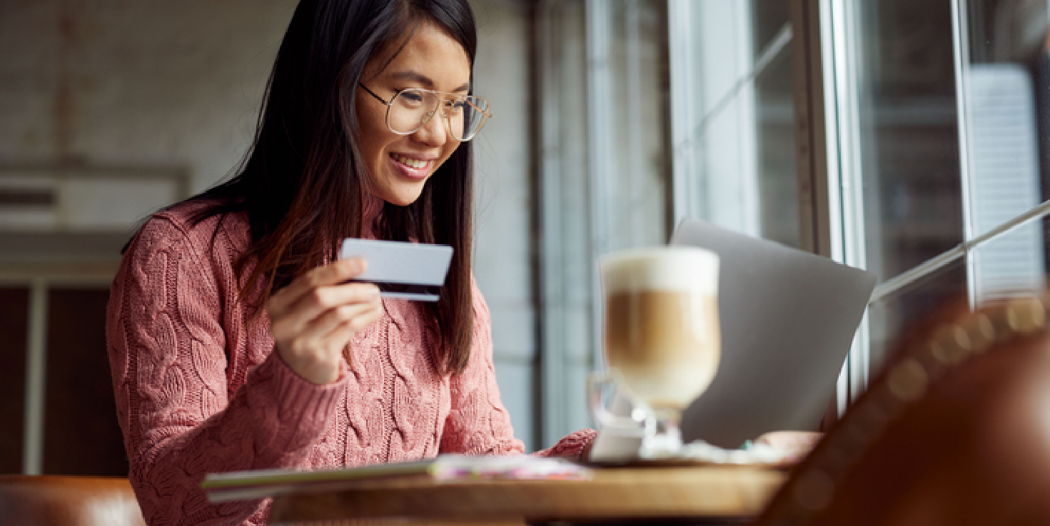 Young Woman Checking her bank account, smiling.