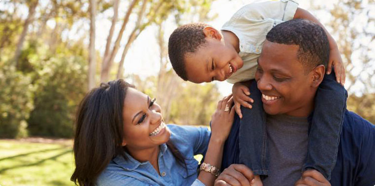 Young parents experiencing peace of mind while playing with their son at the park.